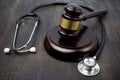 Gavel and stethoscope on black wooden background Royalty Free Stock Photo