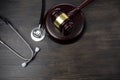 Gavel and stethoscope on black wooden background Royalty Free Stock Photo