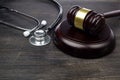 Gavel and stethoscope on black wooden background Royalty Free Stock Photo