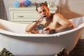 Gay in bath tub. Hygiene routine, bearded man shave beard hair in bathtub. Royalty Free Stock Photo