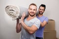 Gay couple carrying rolled up carpet