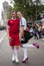 Gay couple in heels, dressed as football players.