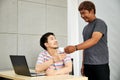 Gay couple in office. Attractive Asian men drinking coffee together