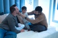Gay couple playing with their daughter on the marriage bed in their home