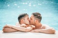 Gay couple relaxing in swimming pool. LGBT. Two young men enjoying nature outdoors, kissing and hugging Royalty Free Stock Photo