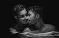 Gay couple relaxing in swimming pool. LGBT. Two young men kissing and hugging Royalty Free Stock Photo