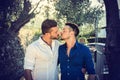 Gay couple walking in park and kissing