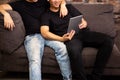 Gay couple watching and looking at phone tablet together. Portrait of happy gay men - Homosexual love concept.