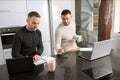 Gay couple working together at home with their laptops. Royalty Free Stock Photo