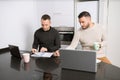 Gay couple working together at home with their laptops. Royalty Free Stock Photo