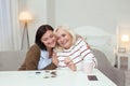 Gay elder woman and caregiver gathering puzzle Royalty Free Stock Photo