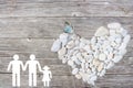 Gay Family on wooden background with white stones heart and blue butterfly