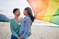 Gay, flag and lesbian couple at the beach for travel, freedom and bond, care and happy in nature together. Rainbow, love Royalty Free Stock Photo