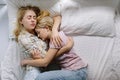 Gay lesbian couple of young girls are lying in bed and cuddling, top view. Concept of love, gay marriage and pride Royalty Free Stock Photo