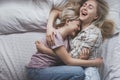 Gay lesbian couple of young girls are lying in bed laughing and cuddling, top view. Concept of love, gay marriage and pride Royalty Free Stock Photo