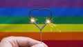 Gay lesbian pride LGBT rainbow flag background - Proud man holding sparkling heart sparkler in his hand