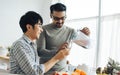 Gay LGBT sweet Asian couple wearing pajamas, smiling, with happiness and love while making and pouring juice smoothie to glass and Royalty Free Stock Photo