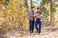 Gay Male Couple With Baby Walking Through Fall Woodland