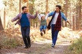 Gay Male Couple With Daughter Walking Through Fall Woodland