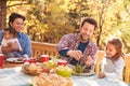 Gay Male Couple Having Outdoor Lunch With Daughters