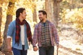 Gay Male Couple Walking Through Fall Woodland Together