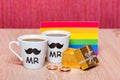 Two cups of coffee, gay flag and a gift box with marriage ring