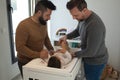 Gay married couple changing their daughterÃÂ´s diaper in the bedroom Royalty Free Stock Photo