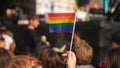 Gay person wave little rainbow flag. People crowd celebrate LGBT pride festival. Royalty Free Stock Photo