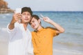 Gay portrait young couple smiling taking a selfie photo together with smart mobile phone at beach Royalty Free Stock Photo