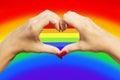 Gay pride concept. Womans hands making heart sign with gay pride LGBT rainbow flag Royalty Free Stock Photo