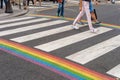 Gay pride flag crosswalk in Paris gay village with people crossing Royalty Free Stock Photo