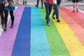 Gay pride flag crosswalk in Vancouver gay village with people crossing Royalty Free Stock Photo