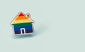 Gay pride rainbow in a silver home shape pin isolated on pastel green background. Copy space included. LGBTQ people right to live