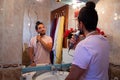 Gay transsexual guy shaving in the mirror getting ready for a date Royalty Free Stock Photo