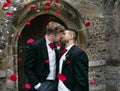 Gay wedding, grooms leave village church after being married to smiles and confetti Royalty Free Stock Photo