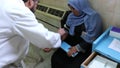 Gaza city, a young woman being vaccinated and attended to by a doctor in a hospital