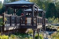 A gazebo attatched to a wooden deck in beautiful garden