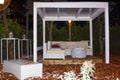 Gazebo in the autumn park at night, illuminated by lanterns. Covered seating area. Royalty Free Stock Photo