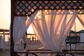 Gazebo on the beach by the sea. Sand beach. Curtains develop in the wind Royalty Free Stock Photo