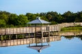 Gazebo and boardwalk over a lake with reflections in the water