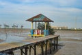 a gazebo at the end of the wooden pier on the edge of the harbor beach Royalty Free Stock Photo