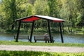 Gazebo in a park on the lake shore and a resting person from the back.