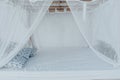 Gazebo with a wooden bed under a mosquito grid on a outside