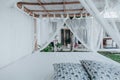 Gazebo with a wooden bed under a mosquito grid on a outside