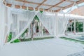 Gazebo with a wooden bed under a mosquito grid on a outside