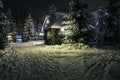 Gazebo, wooden house and Christmas trees in the snow at night. A trodden door leads to the gazebo. Lanterns and garlands Royalty Free Stock Photo