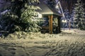 Gazebo, wooden house and Christmas trees in the snow at night. A trodden door leads to the gazebo. Lanterns and garlands Royalty Free Stock Photo