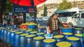 Seller of raw green olives of new harvest on a market stall