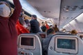 Impatient people with protective mask stand in airplane corridor to get off as soon as possible after landing of Turkish Airlines