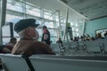 Gaziemir, Izmir, Turkey - 03.11.2021: an old man with protective mask sitting on chairs in airport and wait for his flight time